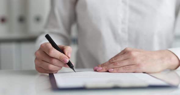 Businesswoman Examines Document and Puts Signature Closeup