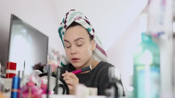 Young Woman Making Herself Makeup with Special Brush