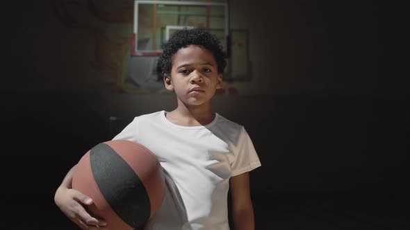 Portrait of Black Boy on Indoor Basketball Court