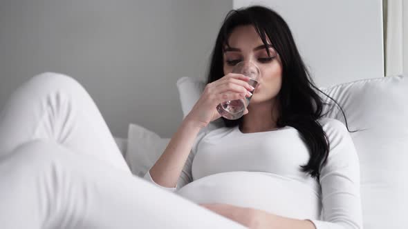 Drink Water. Pregnant Woman Drinking Water From Glass At Home