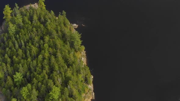 Aerial footage of remote lake in northern Maine spinning past island a revealing the forest along sh