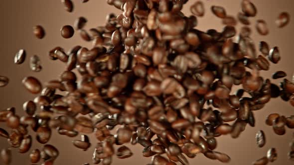 Super Slow Motion Shot of Crashing Coffee Beans on Brown Gradient Background at 1000Fps