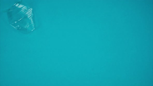 Blue Background with Falling Plastic Cups on Both Sides. Place for Text. Stop Motion