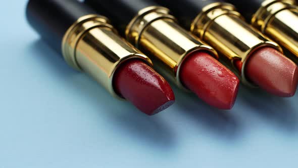 A slider of movement of lipsticks of different colors. Cosmetics for women, closeup of lipsticks