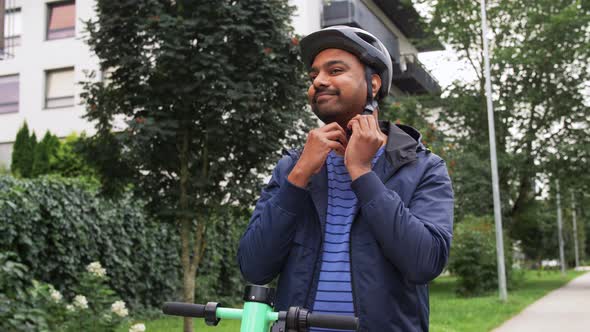 Man in Helmet Riding Electric Scooter on Street