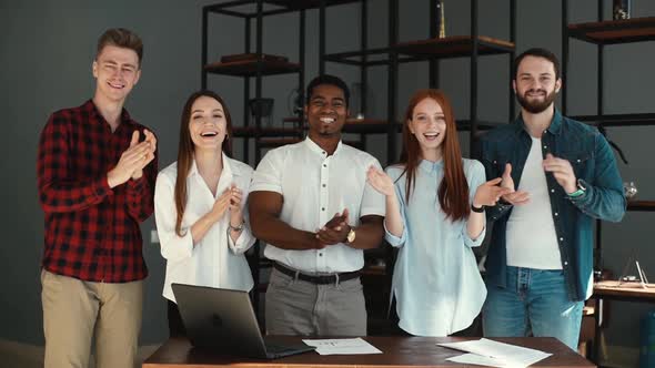 Cheerful Group of Multi-ethnic Business People Applauding and Smiling Gratefully Looking Into Camera