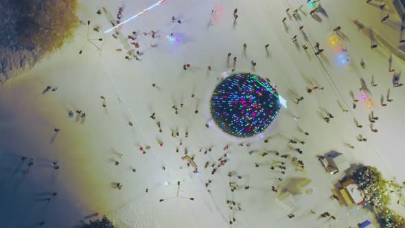 Xmas Tree with Bright Neon Lights and People in City Park