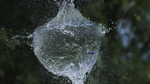 700011 Shot breaking water filled blue balloon, slow motion