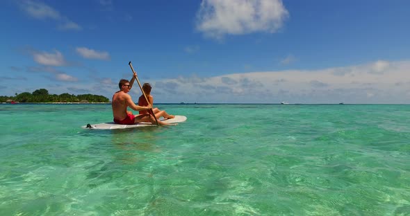 Young man and woman on honeymoon vacation enjoy luxury on beach on sunny white sandy background 