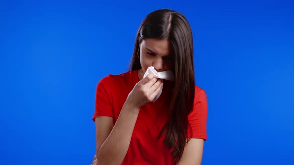 Woman Sneezes Into Tissue