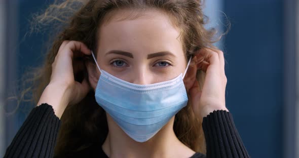 Portrait of Young Girl Teenager Curly Beautiful Woman Putting on Medical Surgical Protective Mask on