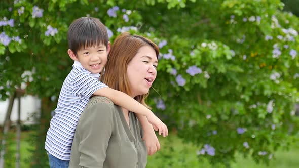 Happy Asian Mother Playing With Her Son In The Park