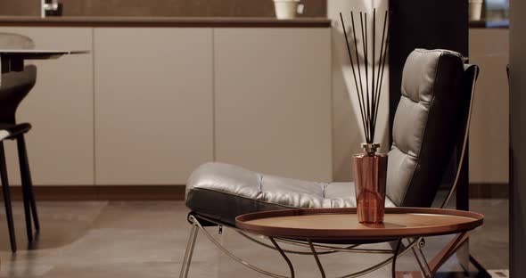 Leather modern black chair in living room with kitchen and dining table.