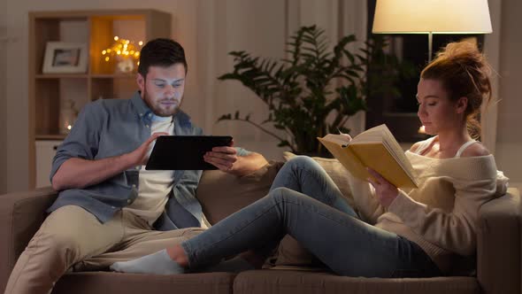 Couple with Tablet Computer and Book at Home 2