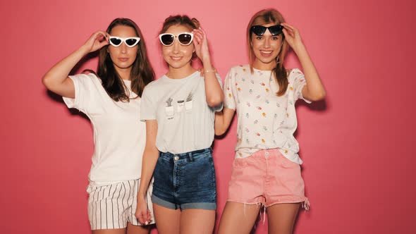 Three young beautiful smiling hipster girls in summer clothes