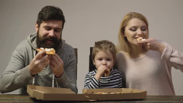 Father Mother and Son Eating Pizza at Home. Kid Boy with Favorite Food. Happy Family Food Concept