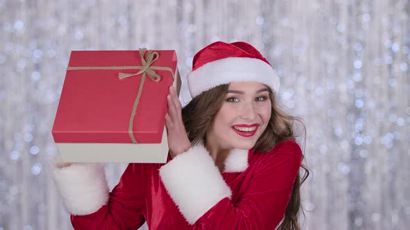 Girl in a Snow Maiden Costume Holds a Gift in Her Hand and Waves Her Hand, Hello. Bokeh Background