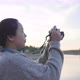 Back view of Asian woman standing and taking a picture by the river - VideoHive Item for Sale
