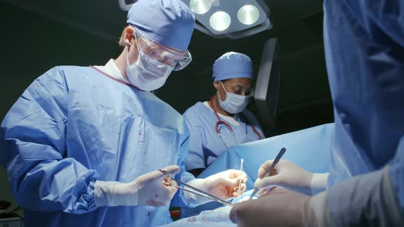 Team of Surgeons Stitching Patient