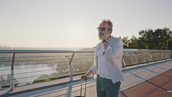 Pensioner Calls to Friend By Smartphone Walking at Sunrise