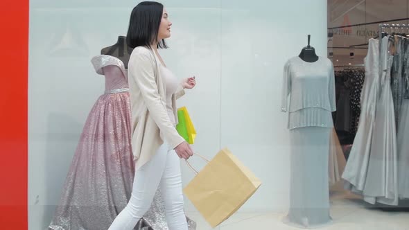 Attractive Woman with Shopping Bags Looking at Shop Window