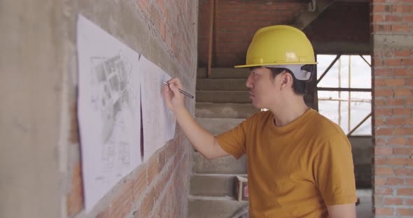 Male Building Designers Wearing Helmets And Drawings Blueprints