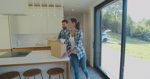 Couple Carrying Boxes Into New Home On Moving Day.