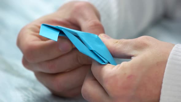 Close Up Male Hands Folding Origami Figure.