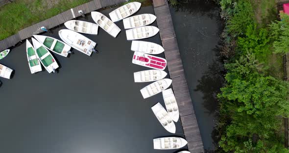 Aerial Shot Of Row Boats Piled In A Wooden Dock During Summer