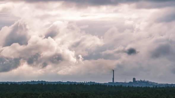 Gray Cumulus Clouds Moves Over the Horizon and an Industrial Plant Timelapse