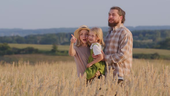 Caucasian Mother Holding Little Girl Pointing Direction with Index Finger Showing Talking Explains