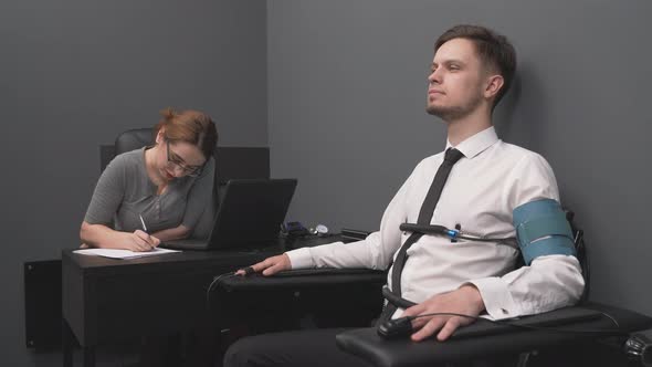 Bearded Man with Pulse Sensors Undergoing Polygraph Test