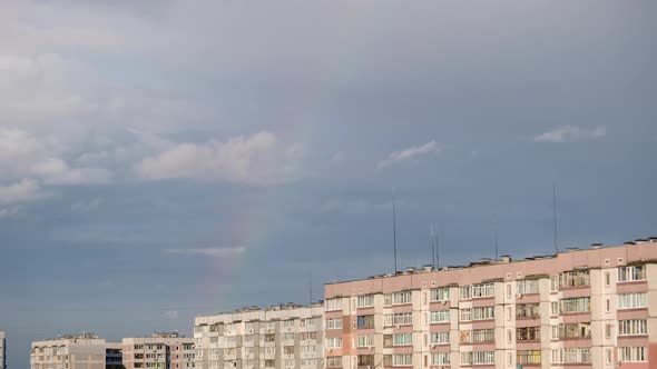 Huge Rainbow in the Cloudy Sky Above the Houses in City Timelapse