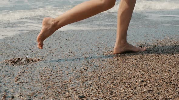 Woman's Feet Running on the Hot Sunny Sand Beach