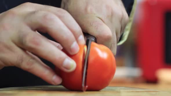 Cook Cuting Tomato in the Kitchen