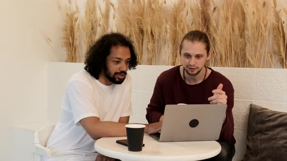 International Men Young Freelancers Friends Are Working On A New Project, Using A Laptop