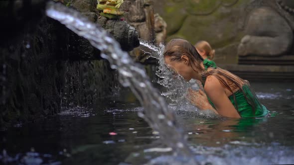 Slowmotion Shot of a Young Woman Visiting the Holly Springs in Indonesia. Tirta Empul Holy Water