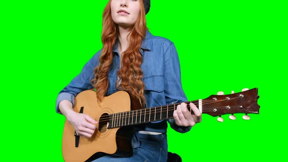 Female musician singing while playing guitar