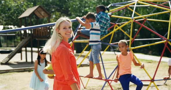 Portrait of happy trainer with schoolkids in playground