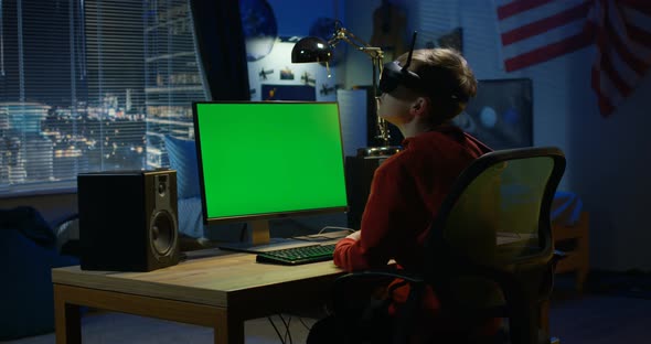 Boy Using a Computer While Wearing VR Headset