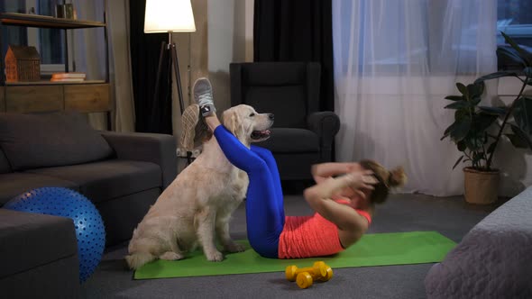 Dog Assisting Female Owner Doing Crunches at Home