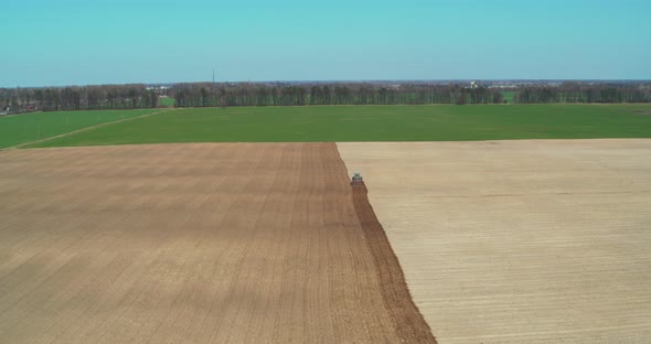 Tractor Plow Cultivating Field in Spring General Plan Aerial View