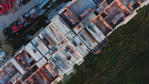 Rotating Aerial Top View of the Construction of a Residential Building at Sunset on a Summer Day