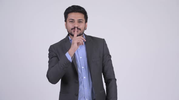 Young Handsome Bearded Indian Businessman with Finger on Lips