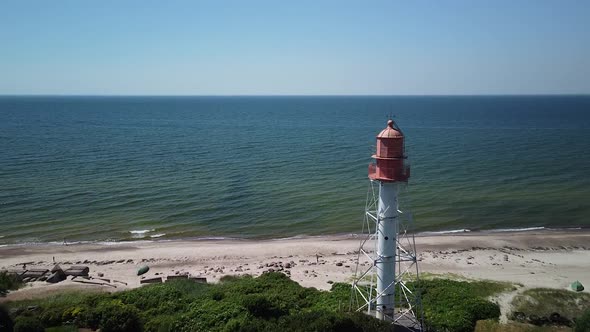 Beautiful aerial view of white painted steel lighthouse with red top located in Pape, Latvia at Balt