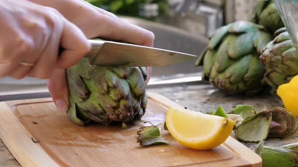 Woman Cut Artichokes. Cooking Process