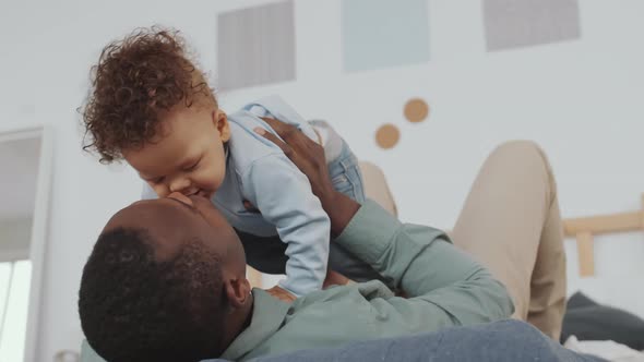 Happy Dad Playing with Cheerful Baby