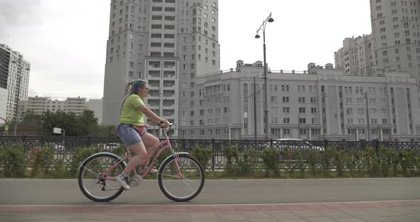 Bright Girl Rides Color Bike Around City