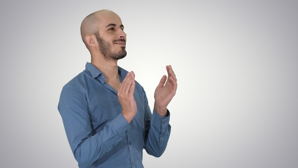 Handsom arab clapping his hands applauding on gradient background.