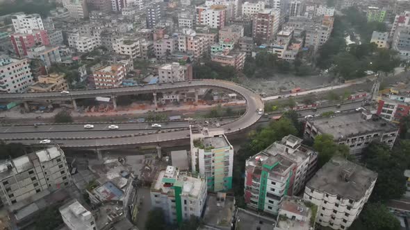 Traffic flow along busy Dhaka highway; aerial time lapse rotation shot
